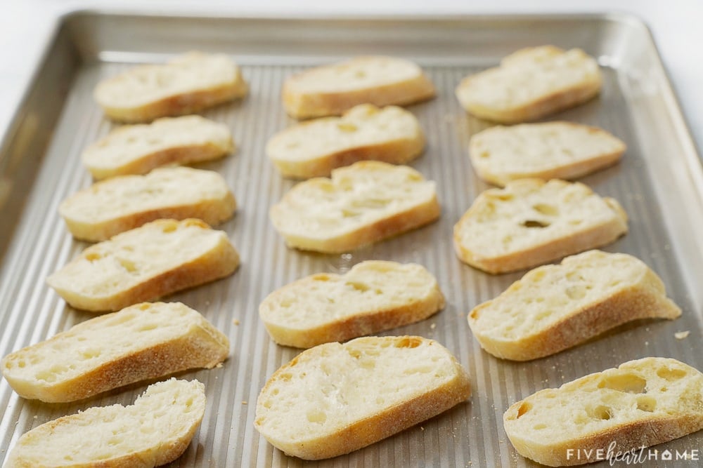 Baguette slices on baking sheet.