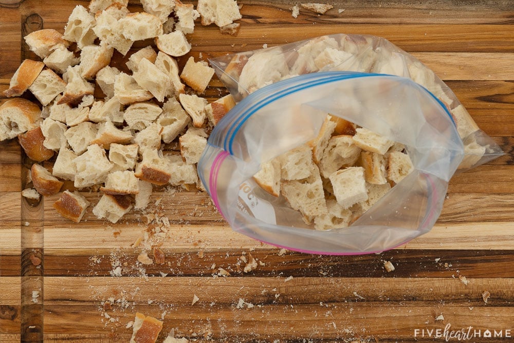 Bread cubes on cutting board and in bag.