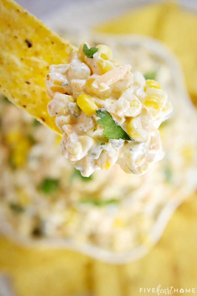 Mexican Corn Dip on tortilla chip with fresh corn and cheese.