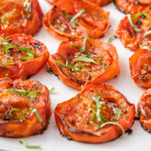 Close-up of Roasted Tomatoes topped with fresh herbs.