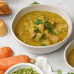 Slow Cooker Split Pea Soup in bowls with dried peas and carrots on side.