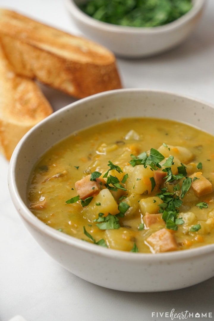 Bowl of Crockpot Split Pea Soup with bread on side.