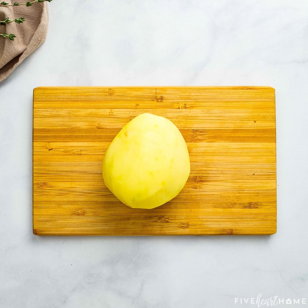 Peeled Yukon Gold on cutting board.