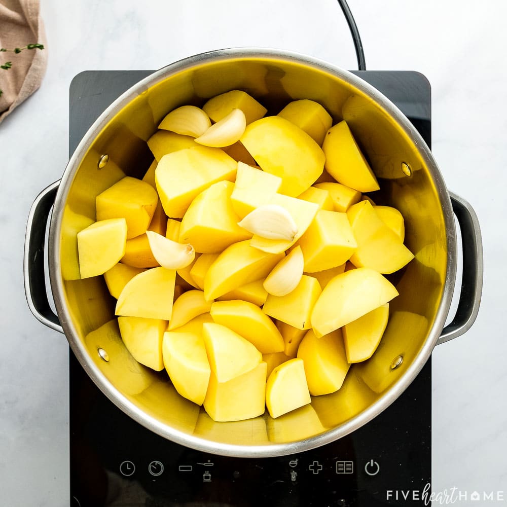 Potatoes and garlic cloves in pot.