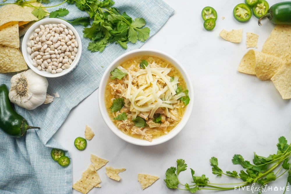 Aerial view of White Bean Chicken Chili with ingredients on table.