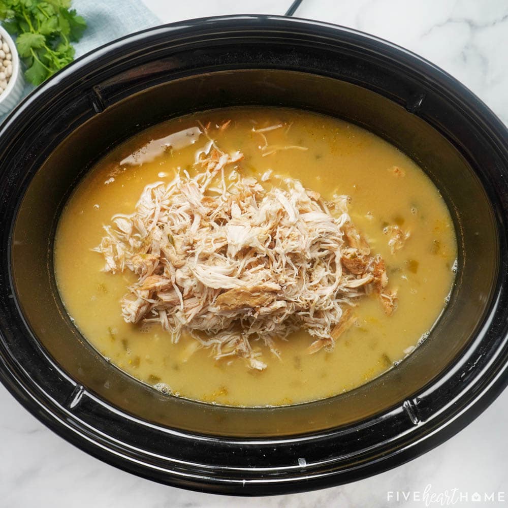 Adding shredded chicken to crockpot.