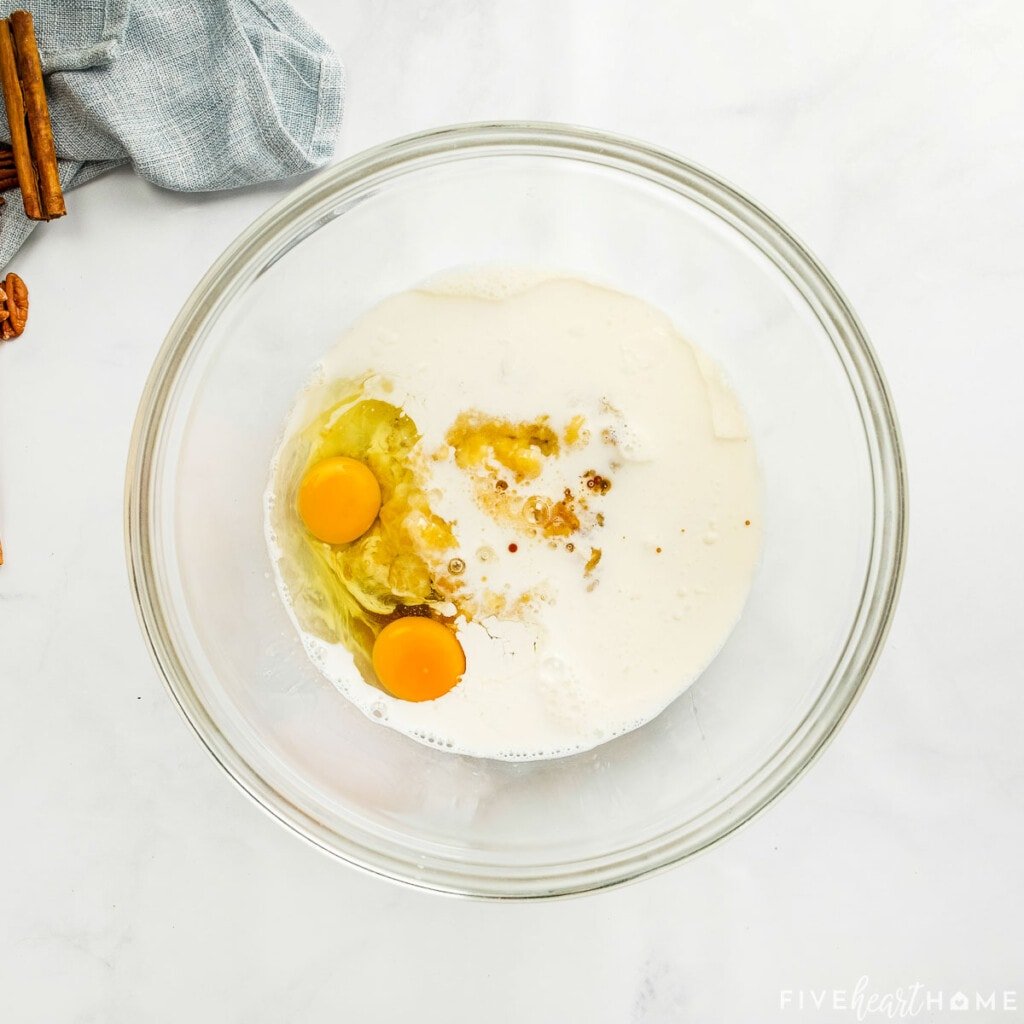 Eggs, milk, and maple syrup in glass bowl.