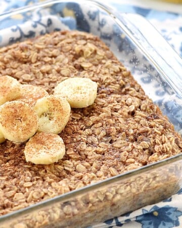 Banana Baked Oatmeal in glass dish with slices of bananas on top.