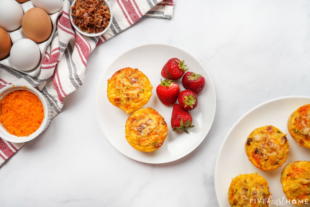 Frittata Muffins on a plate with strawberries for serving.