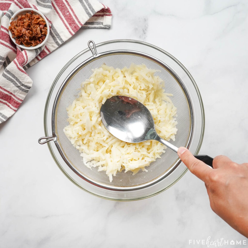 Pressing water out of frozen hash browns.