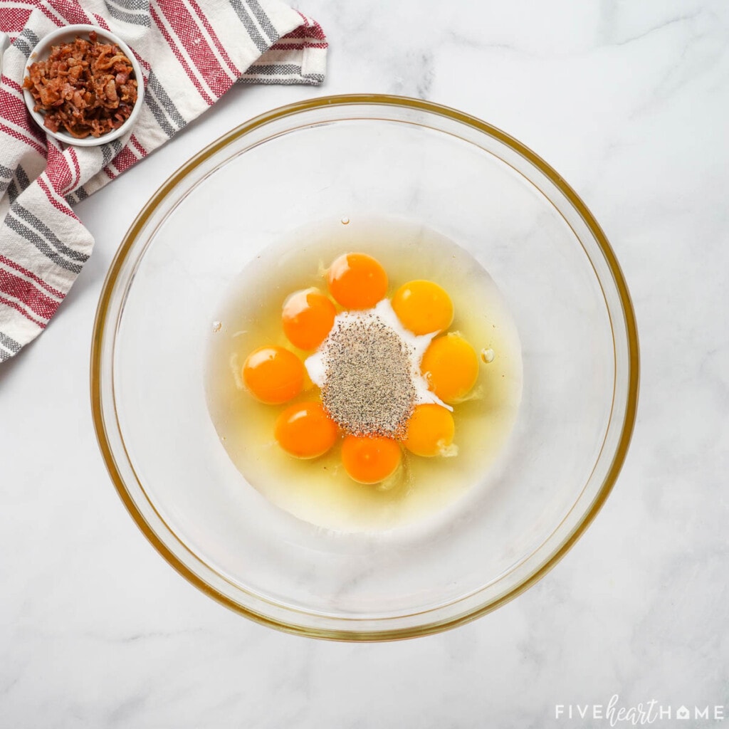 Eggs, milk, salt, and pepper in bowl.