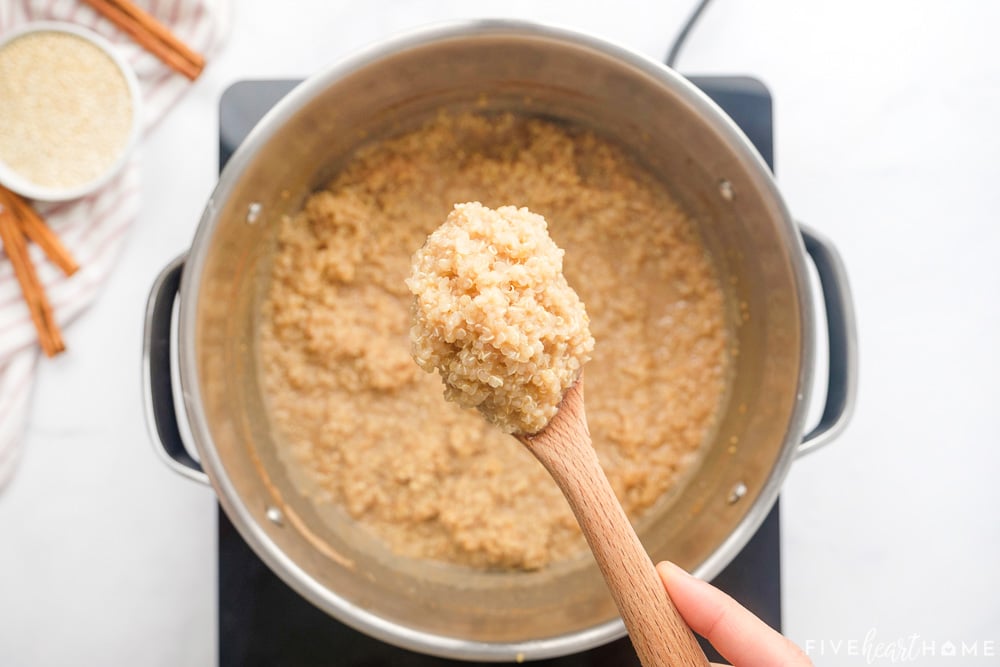 Quinoa Pudding recipe scooped with wooden spoon.