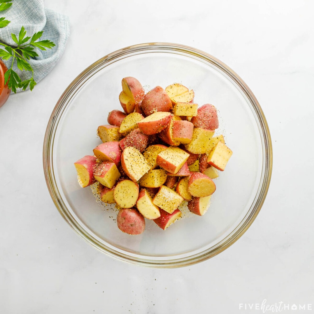 Seasoning red potatoes in bowl.