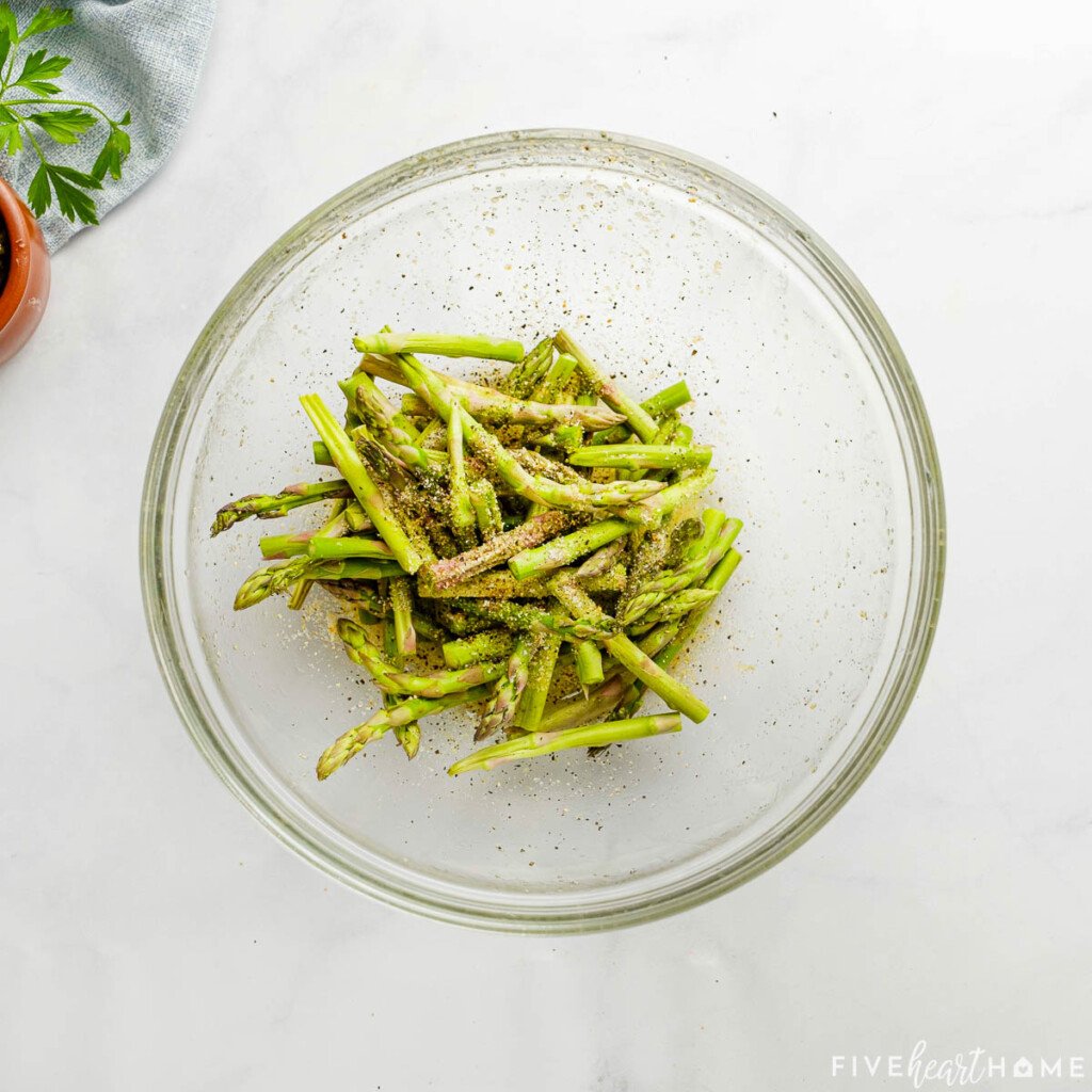 Seasoned asparagus in bowl.