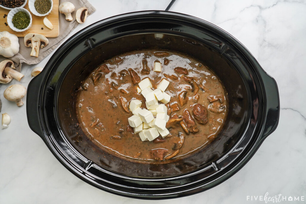 Adding cream cheese to slow cooker.