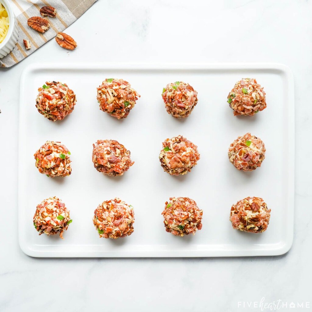 Pimento cheese balls lined up on pan.