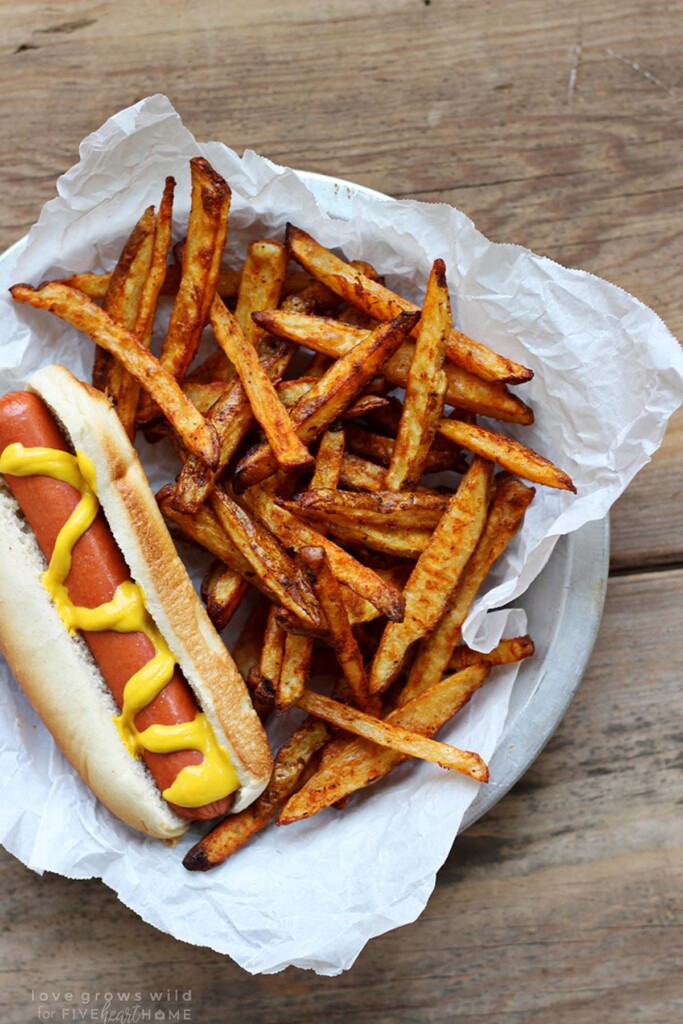 Spicy French Fries in basket with hot dog.