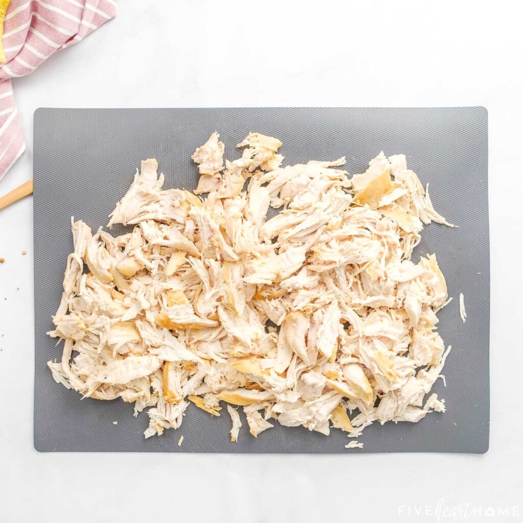 Shredded chicken on cutting board.