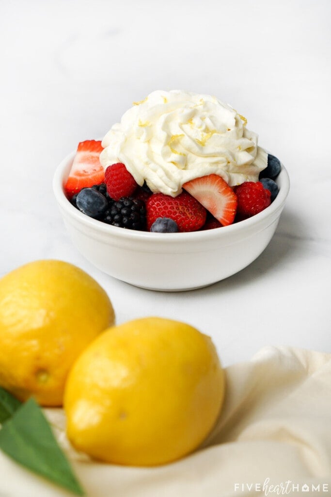 Lemon Whipped Cream recipe atop fresh berries.