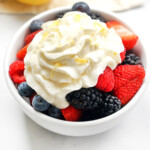 Close-up of Lemon Whipped Cream over berries in bowl.