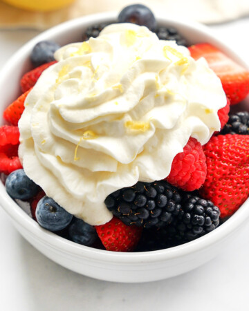 Close-up of Lemon Whipped Cream over berries in bowl.