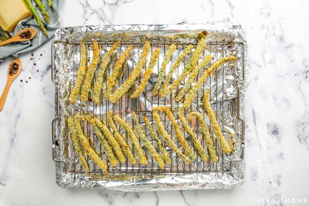 Baked Asparagus Fries on rack in pan.