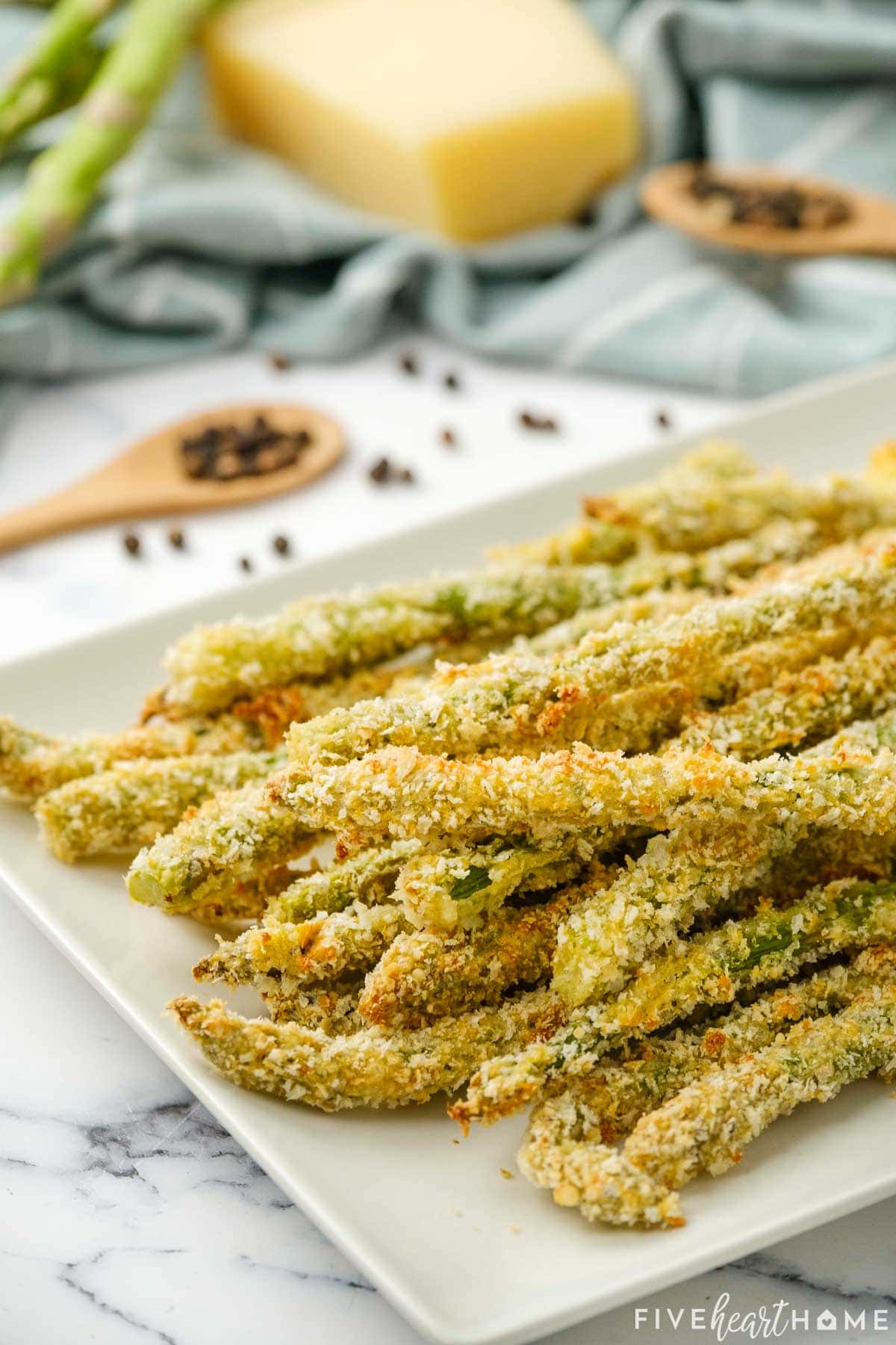 Baked and breaded Asparagus Fries on white platter.