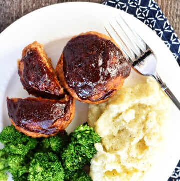 Aerial view of Turkey Meatloaf Muffins on plate with broccoli and mashed potatoes.