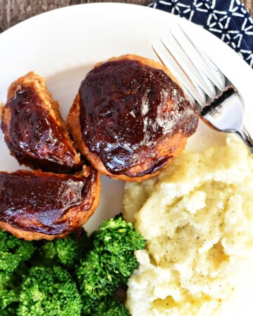 Aerial view of Turkey Meatloaf Muffins on plate with broccoli and mashed potatoes.