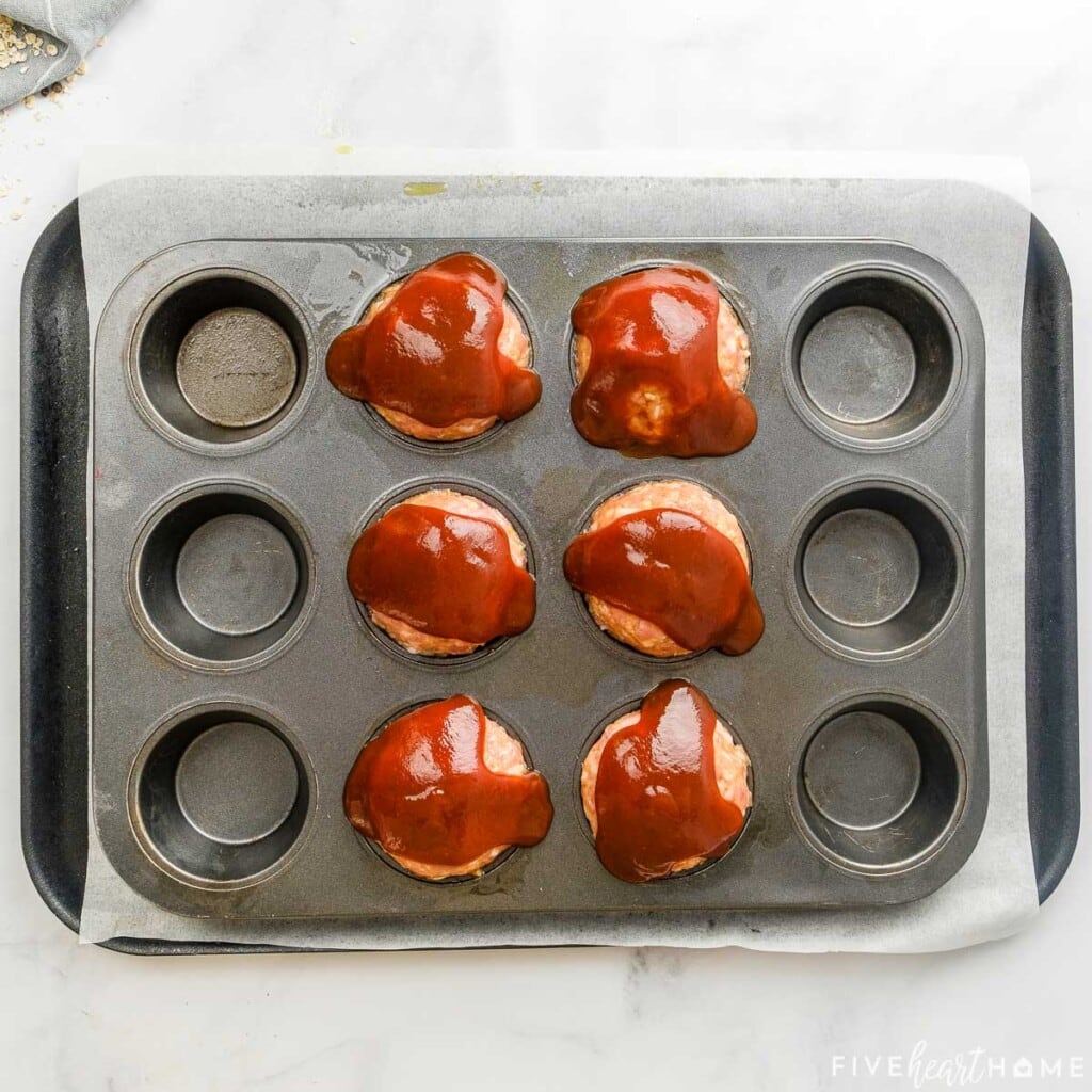 Turkey Meatloaf Muffins in pan, topped with glaze and ready for oven.