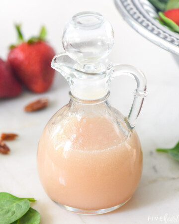 Blush Wine Vinaigrette with spinach and strawberries in background.