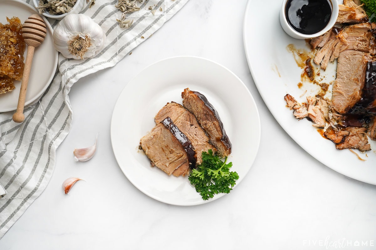 Aerial view of Crock Pot Pork Loin with honey balsamic glaze on plate and platter.