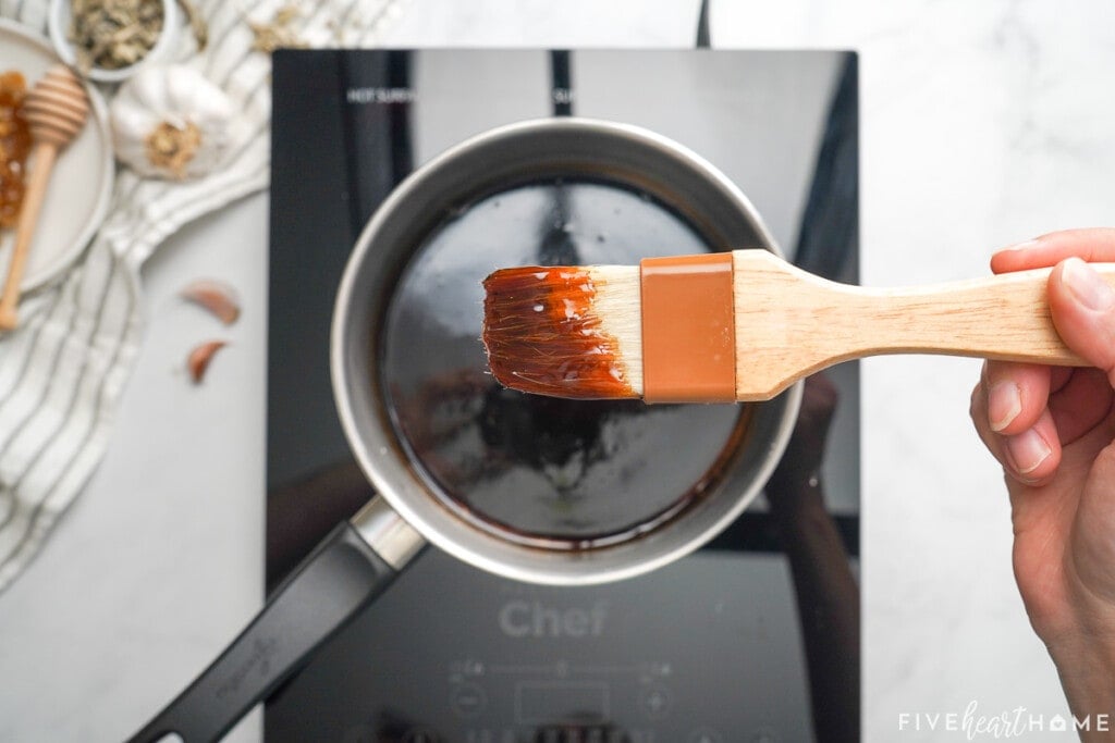 Honey balsamic glaze ready to brush on pork loin in slow cooker.