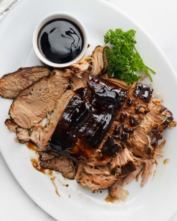 Crock Pot Pork Loin with balsamic glaze on platter.