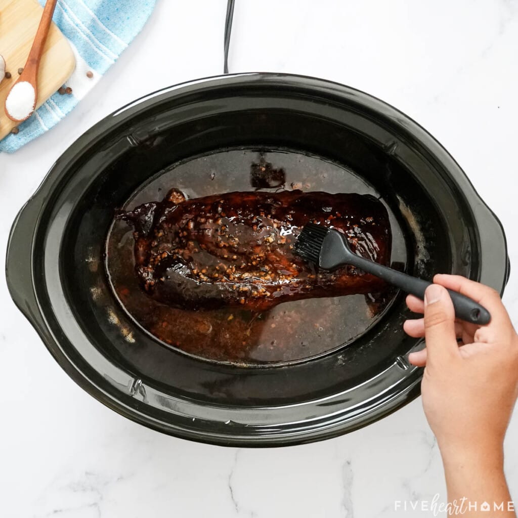 Brushing glaze over Crock Pot Pork Loin.