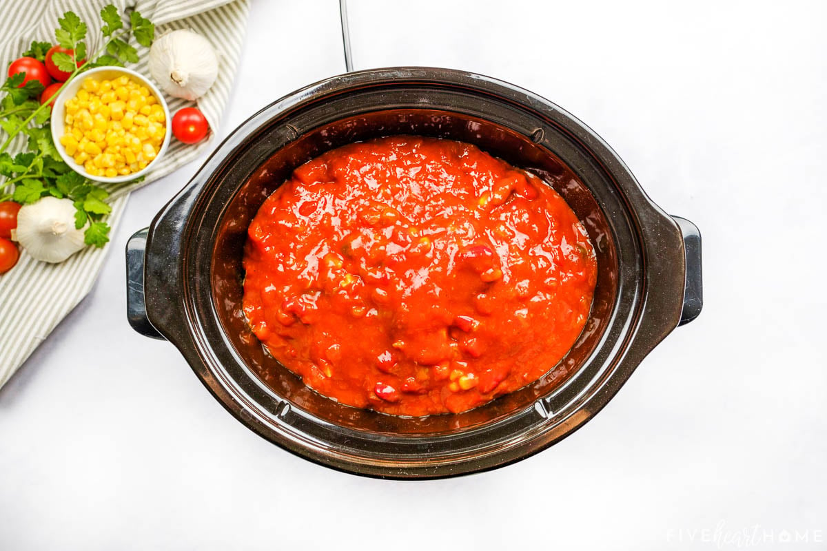 Adding salsa to slow cooker for crock pot shredded chicken tacos.