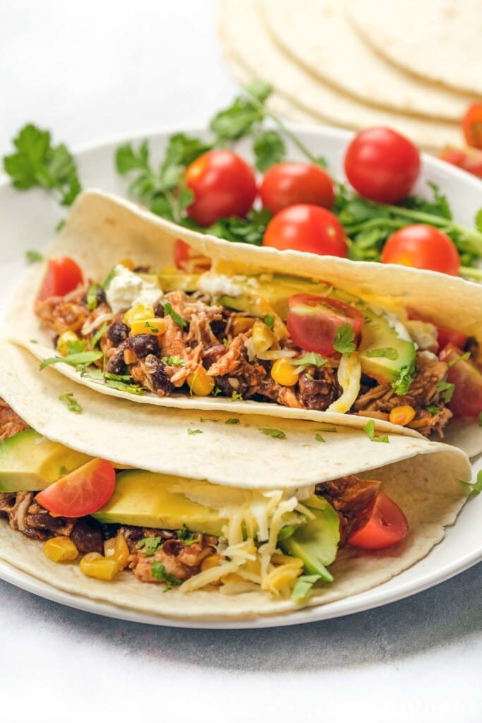 Crockpot chicken tacos with toppings.