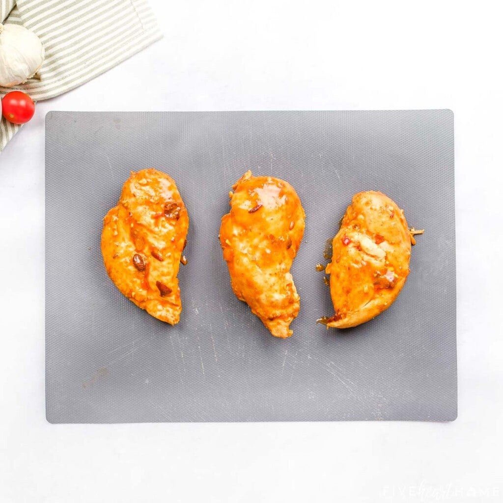 Chicken breasts on cutting board.