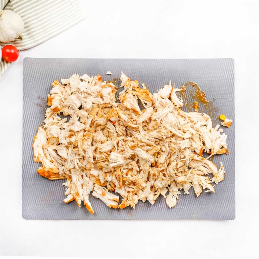 Shredded chicken for tacos on cutting board.