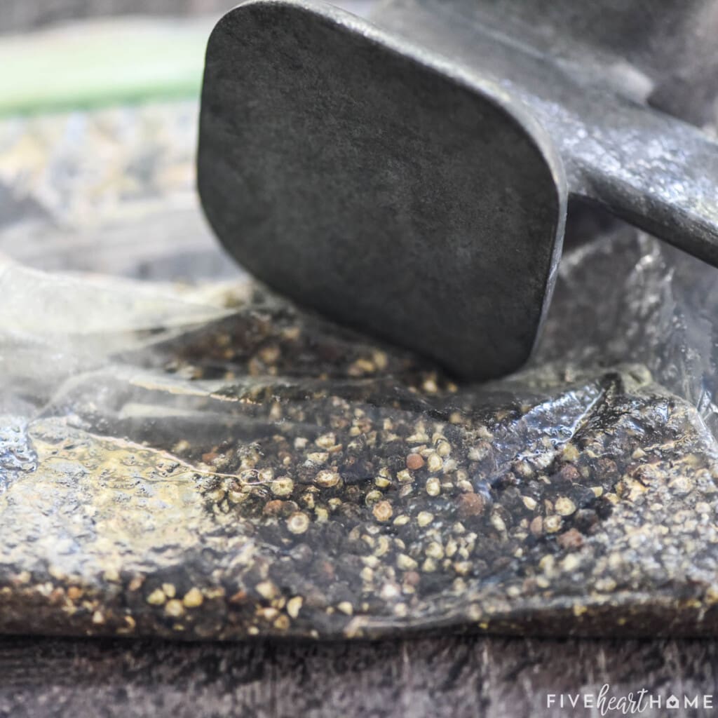 Crushing peppercorns with meat mallet to make Lemon Pepper Seasoning.