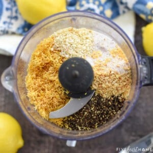 Aerial view of Lemon Pepper Seasoning ingredients in food processor; how to make lemon pepper seasoning with lemon zest and black peppercorns.