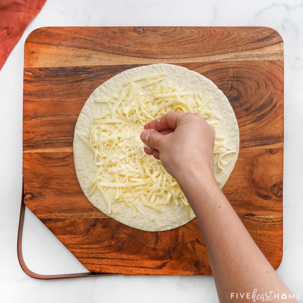 Sprinkling Parmesan onto pizzadilla.