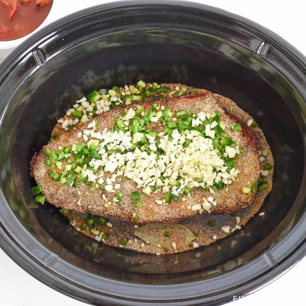 Ingredients in slow cooker to make Crock Pot Shredded Beef for Tacos.