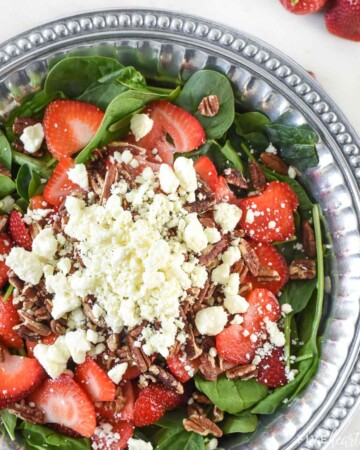 Spinach Salad with Strawberries topped with toasted pecans, feta, and blush wine vinaigrette.