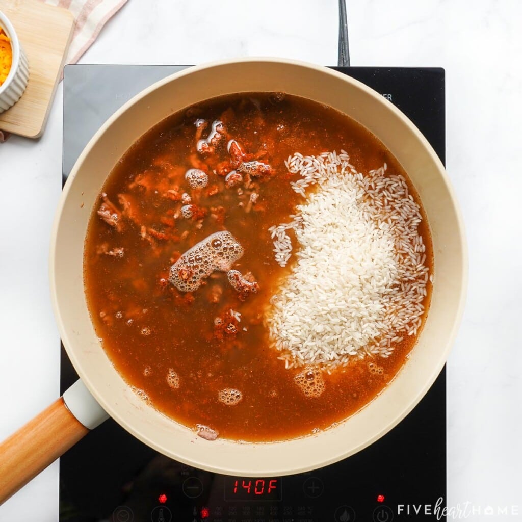 Adding beef broth and rice for homemade Taco Hamburger Helper.