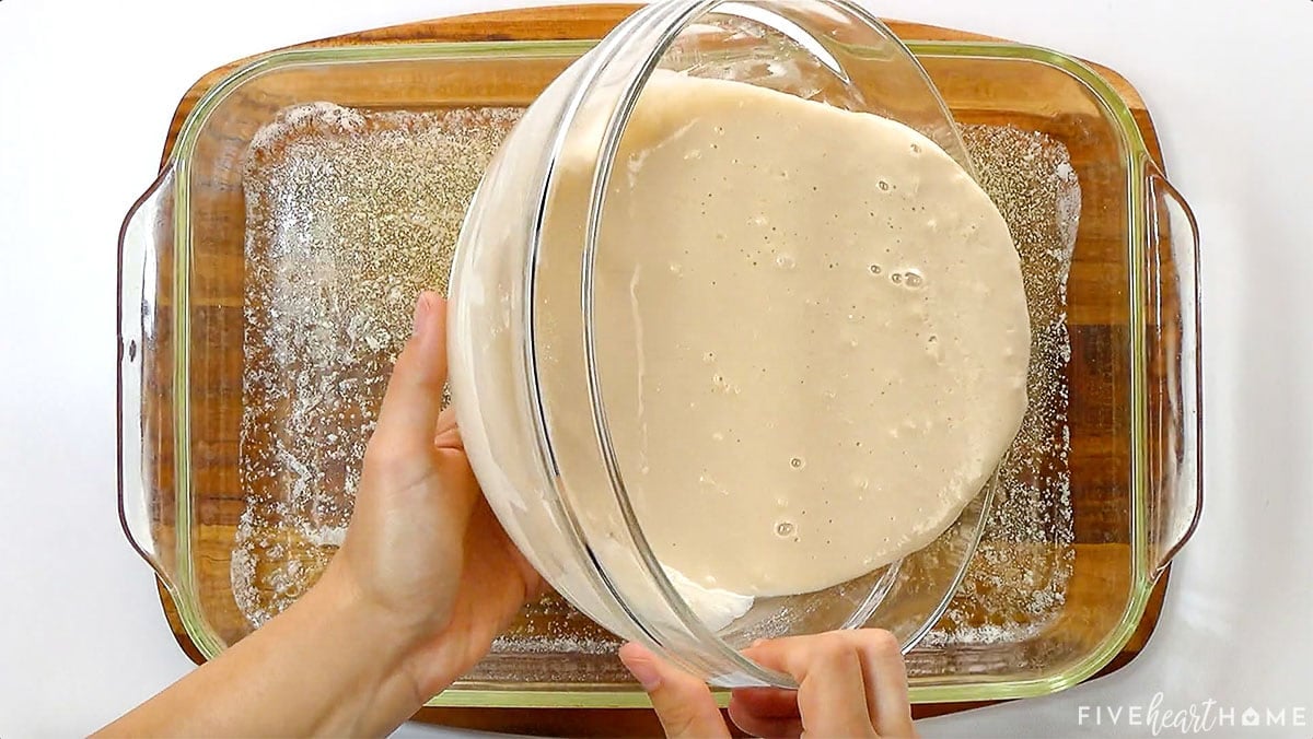 Pouring homemade Blackberry Cobbler batter into glass baking dish of melted butter.