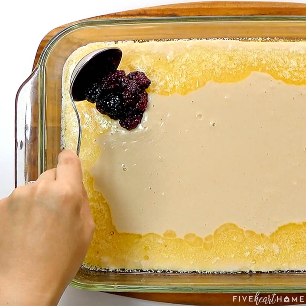 Spooning blackberries onto homemade Blackberry Cobbler.