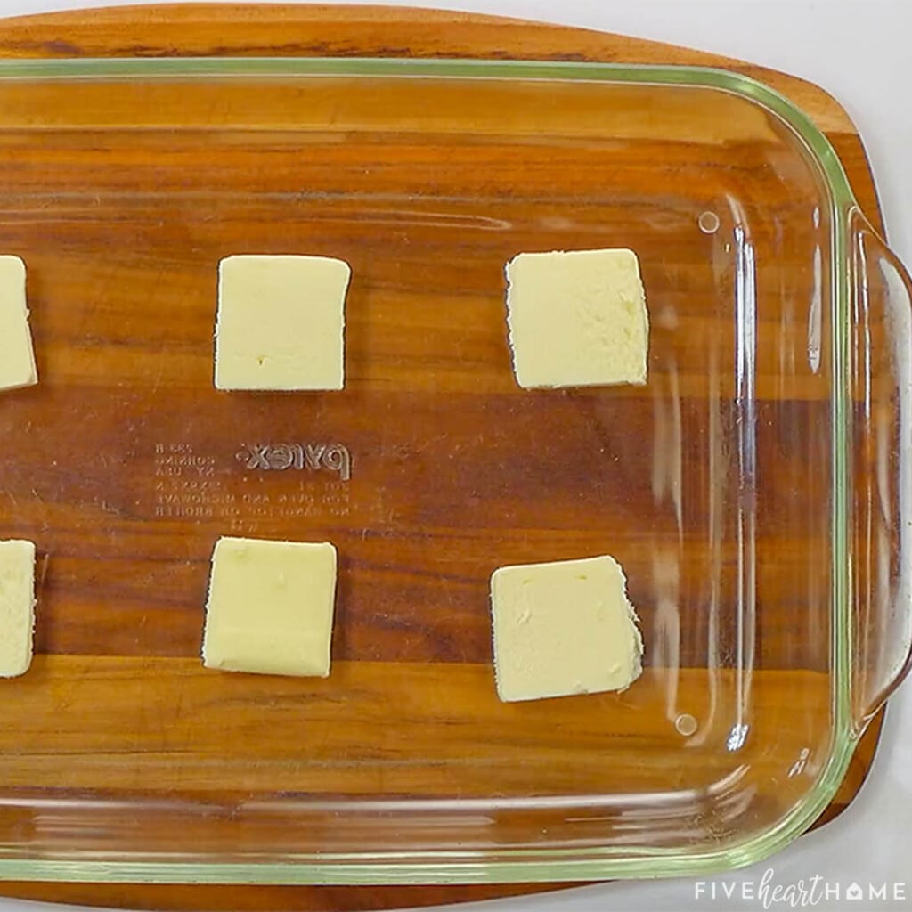 Pats of butter in baking dish.