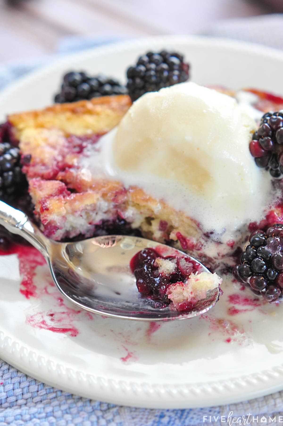 Easy Blackberry Cobbler recipe with ice cream and spoon.