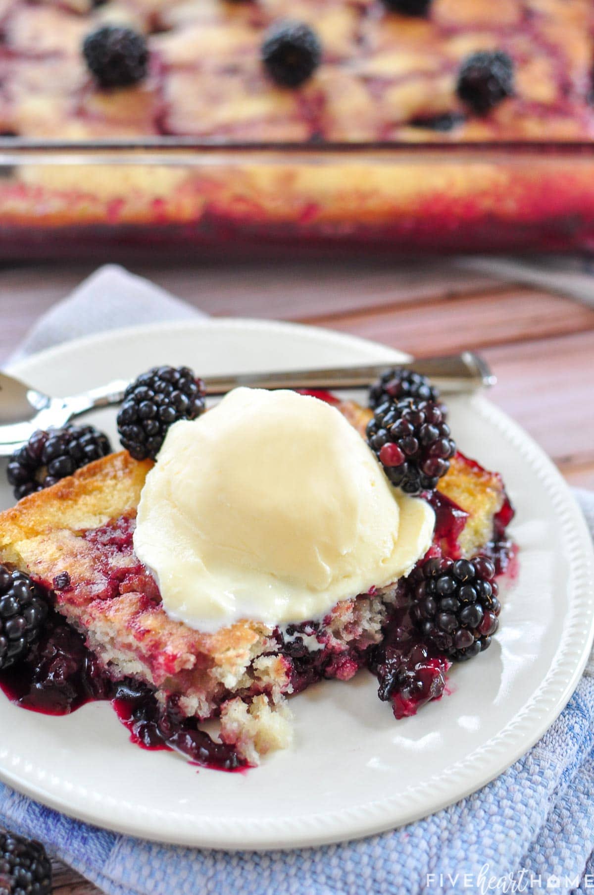 Blackberry Cobbler recipe on a plate with ice cream on top.